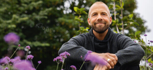 Søren Vester sidder i sin have hjemme i Thise og smiler - han fløjter når han arbejder, fordi krop og hoved er i balance